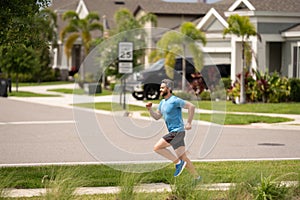 Male jogger running in park. Full length portrait of an athletic young man running outdoor. Sport and healthy lifestyle