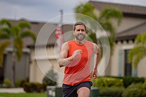 Male jogger running in park. Full length portrait of an athletic young man running outdoor. Sport and healthy lifestyle