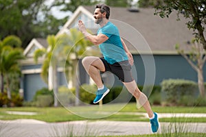 Male jogger running in park. Full length portrait of an athletic young man running outdoor. Sport and healthy lifestyle