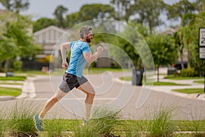 Male jogger running in park. Full length portrait of an athletic young man running outdoor. Sport and healthy lifestyle