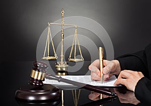 Male judge signing document at desk