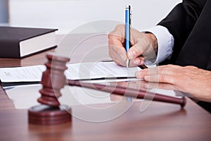 Male judge writing on paper