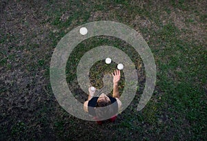 Male juggler juggling with balls from above