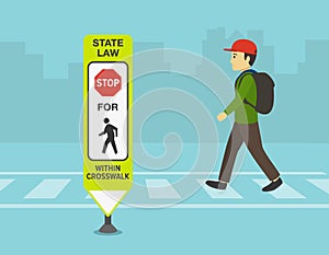 Male kid crossing the street on crosswalk. Close-up of a `Stop for pedestrians within crosswalk.