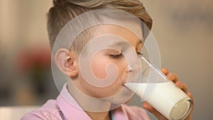 Male kid drinking milk beverage closeup, morning nutrition, health care, lactose