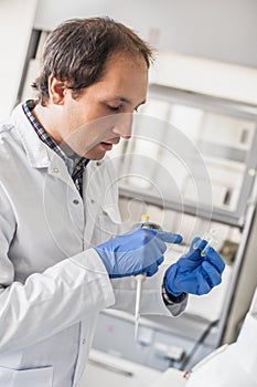 Male lab technician holding a test tube with sample