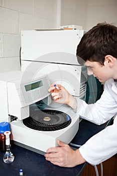 Male laboratory assistant using a centrifuge