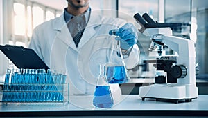 Male Laboratory technician holding a flask with a microscope