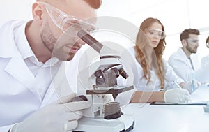 Male laboratory technician looking at samples in the microscope