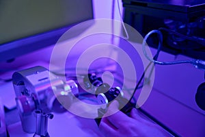 Male laboratory worker controlling joystick of micromanipulator