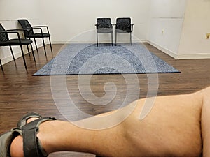 male with large calves sitting in waiting room with chairs