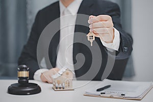 Male lawyer or judge delivering keys to customer. Real estate law and house auction concept.