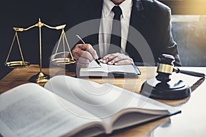 Male lawyer or judge working with contract papers, Law books and wooden gavel on table in courtroom, Justice lawyers at law firm,