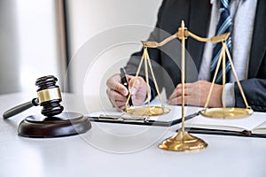 Male lawyer or judge working with contract papers, Law books and wooden gavel on table in courtroom, Justice lawyers at law firm,