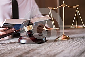 Male lawyer or judge working with Law books, gavel and balance, report the case on table in office, Law and justice concept