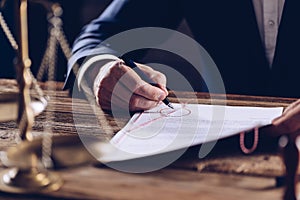 Male lawyer or notary signing document at his office.