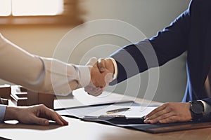 Male lawyer shaking hands with client in office