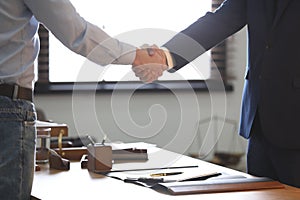 Male lawyer shaking hands with client in office