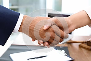 Male lawyer shaking hands with woman over table