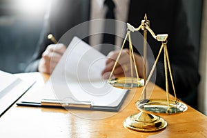 Male lawyer working with contract papers and reading law book in a courtroom, justice and law concept while presiding over trial