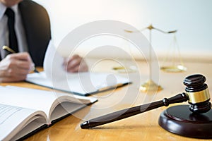 Male lawyer working with contract papers and reading law book in a courtroom, justice and law concept while presiding over trial