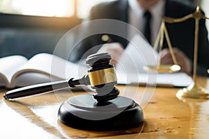 Male lawyer working with contract papers and reading law book in a courtroom, justice and law concept while presiding over trial