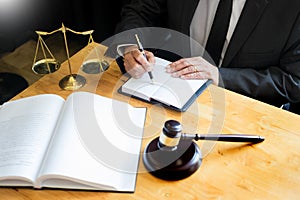 Male lawyer working with contract papers and reading law book in a courtroom, justice and law concept while presiding over trial