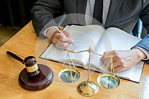 Male lawyer working with contract papers and reading law book in a courtroom, justice and law concept while presiding over trial