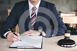 Male lawyer working with gavel and note paper report the case on