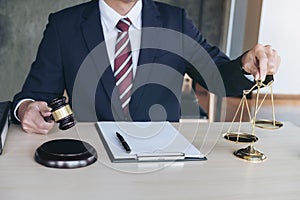 Male lawyer working with gavel and scales of justice, note paper