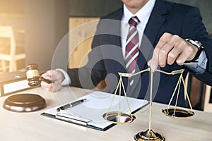 Male lawyer working with gavel and scales of justice, note paper