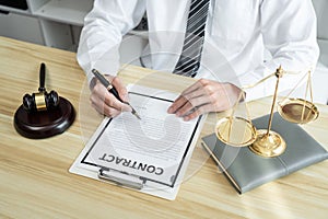 Male lawyer working with litigation contract paper documents of the estate lawsuit, Law books and wooden gavel on table office