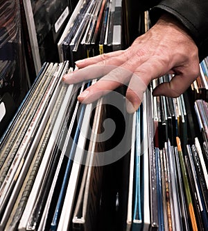 Male in leather jacket browsing through vinyl albums at a record store