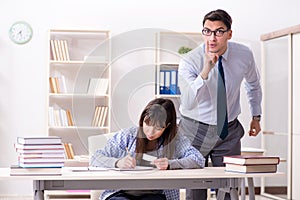 The male lecturer giving lecture to female student