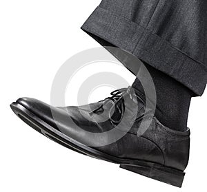 Male left foot in black shoe takes a step