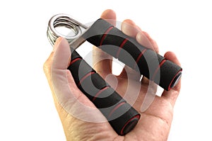 A male left hand holding a black hand muscle gripper trainer