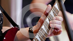 Male left hand playing electric guitar solo. Close-up. Music concept