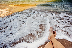 Male legs at the background of surf sea waves