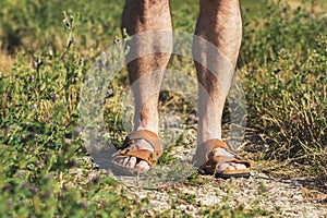 Male legs in brown leather sandals photo