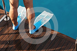 Male legs flippers close up deck yacht