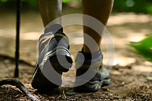 Male legs with hiker boots walking along the forest path. Traveling and adventure concept.