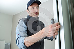 Male lockpicker fixing door handle at home