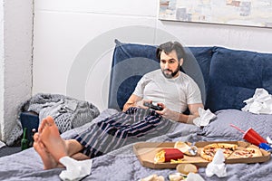 male loner playing video game on bed