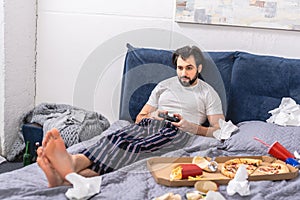 male loner playing video game on bed photo