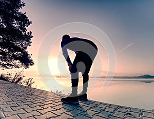 Male long distance runner in endurance training at mountain lake