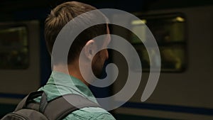 Male making faces and covering ears, subway train making unpleasant sound