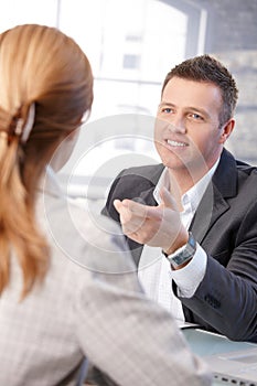 Male manager interviewing female candidate smiling