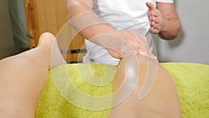 Male manual therapist working with patient in spa salon, chiropractor stroking and stretching female legs and feet. Skin