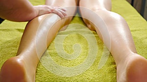 Male manual therapist working with patient in spa salon, chiropractor stroking and stretching female legs and feet. Skin