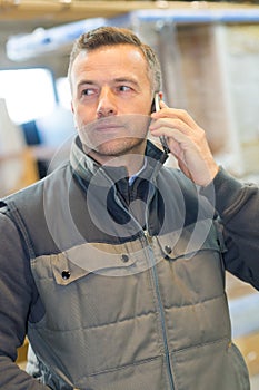 Male manual worker taking call on smartphone